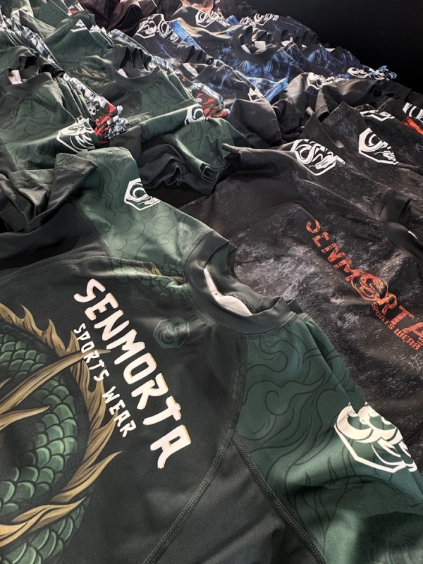 stos ułożonych jedna na drugiej sportowych koszulek typu rashguard